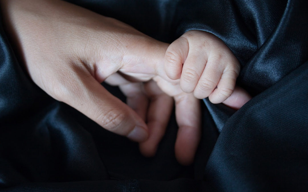 baby holding hands with parent