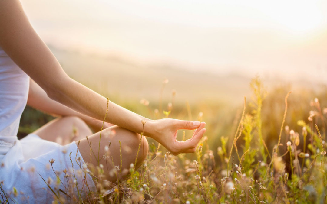 woman meditating in grass